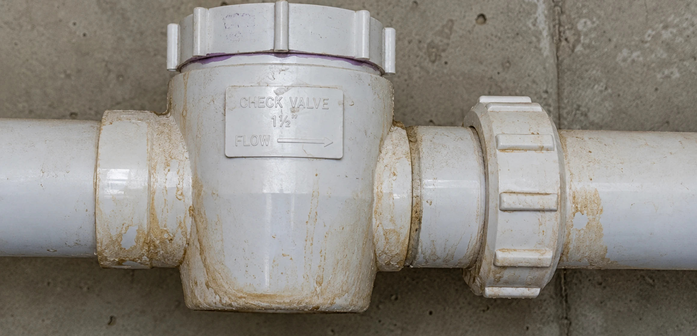 Sump pump battery backup unit mounted on a basement wall near the basin